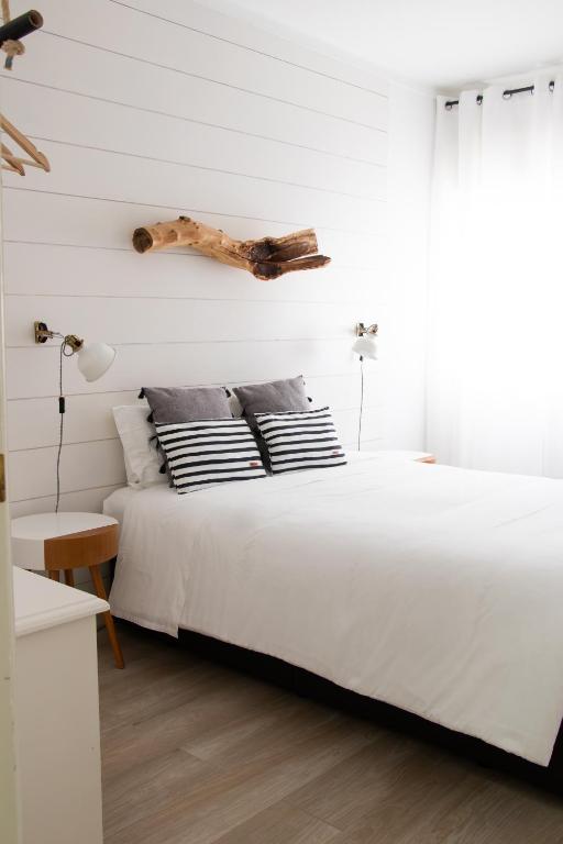 a bedroom with a large white bed with a headboard at Earth Element Apartment in Peniche