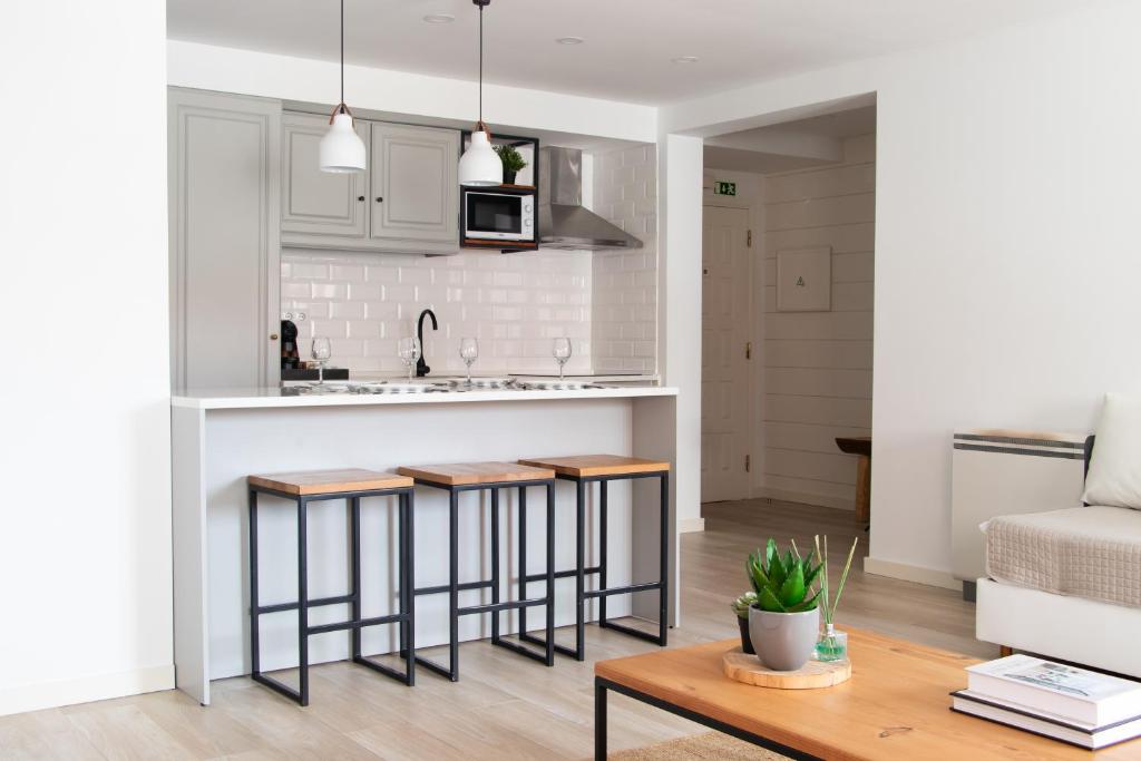a kitchen and living room with bar stools at Earth Element Apartment in Peniche