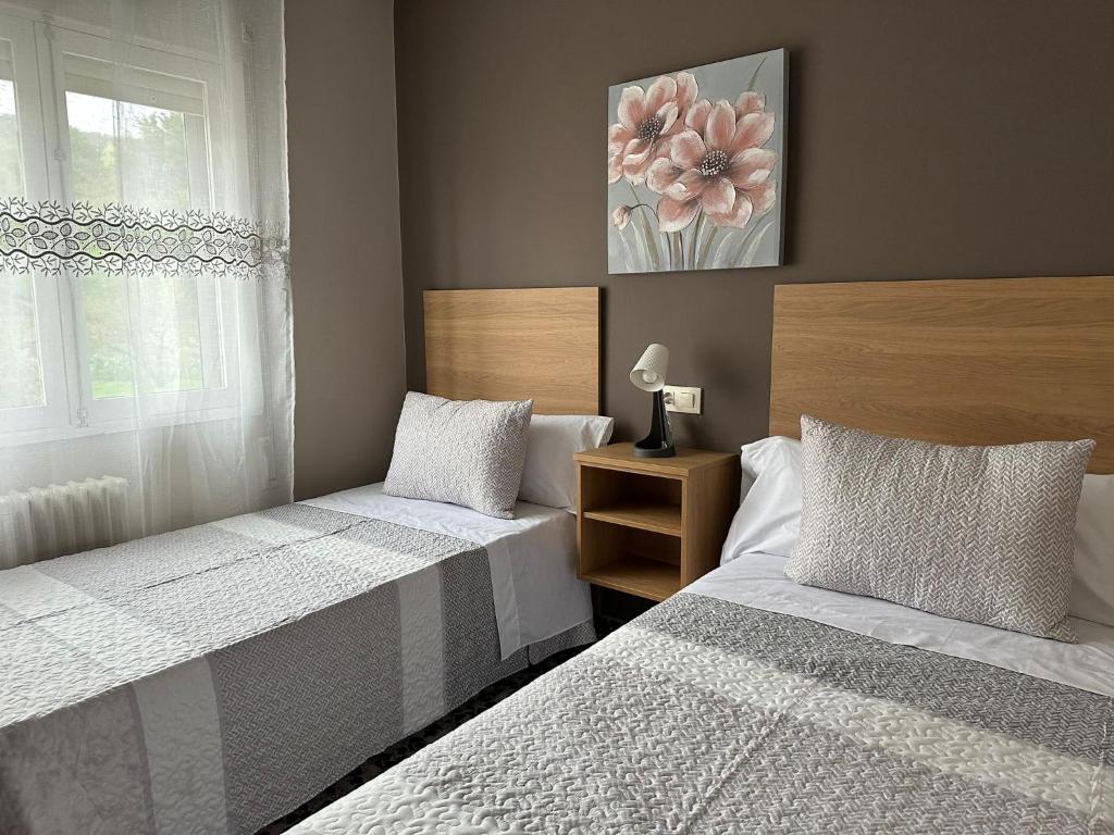 1 dormitorio con 2 camas y ventana en Apartment in the heart of the Camino de Santiago en Sarria