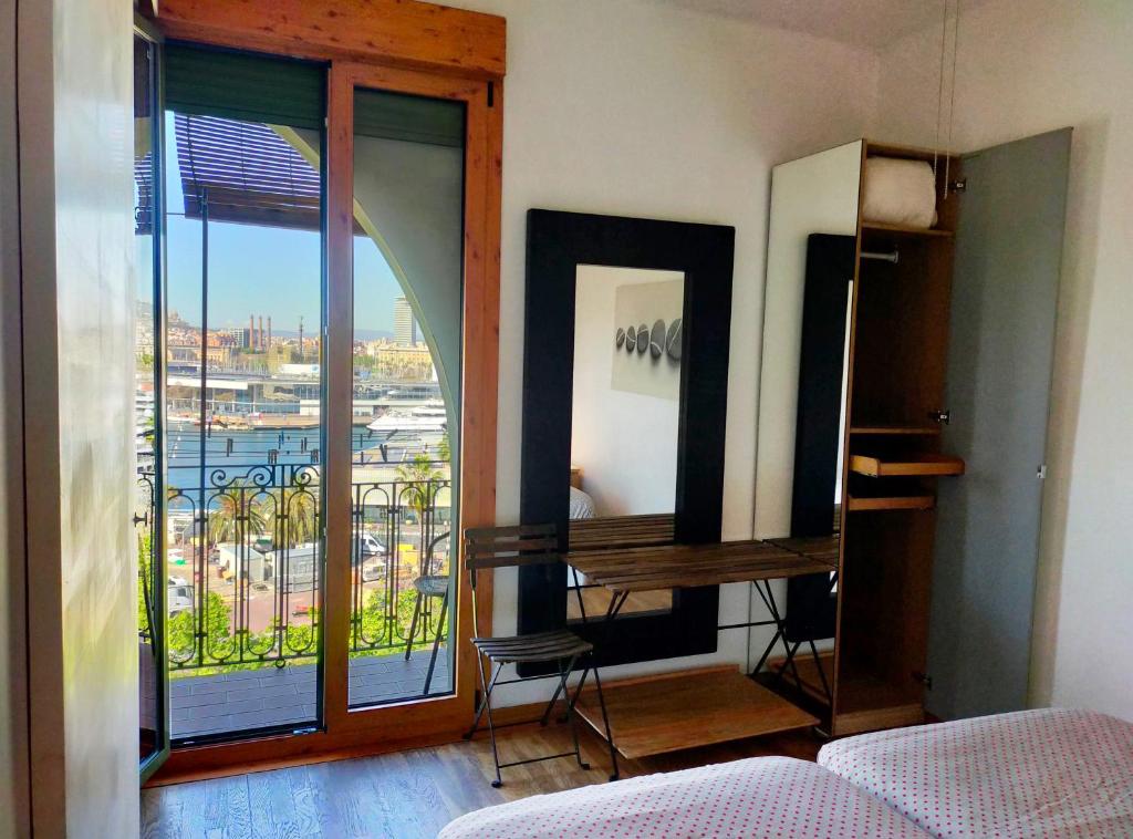 una camera da letto con balcone affacciato sulla città di Barceloneta Port Ramblas a Barcellona