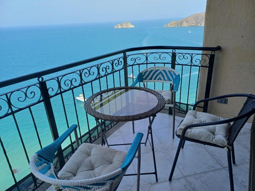 2 sillas y una mesa en un balcón con vistas al agua en Rodadero mágico Apartamento frente al mar, en Santa Marta