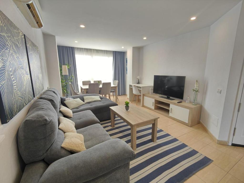 uma sala de estar com um sofá e uma televisão em Vacacional familiar al mar em Candelaria