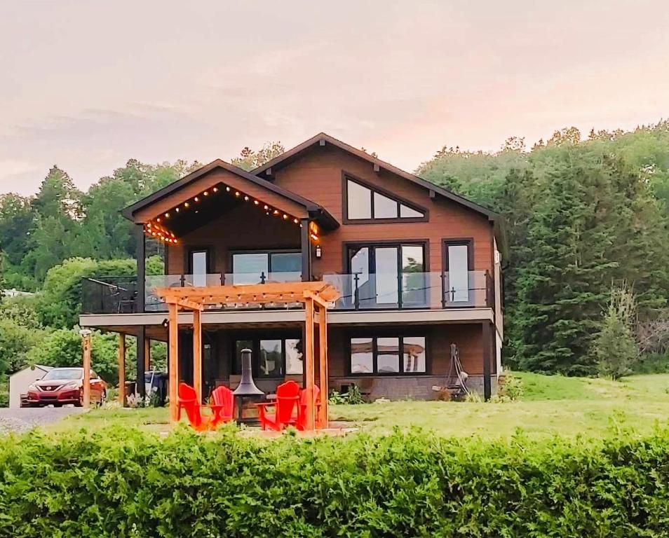 una casa con sillas rojas delante en O Roy des Marees, en Trois-Pistoles