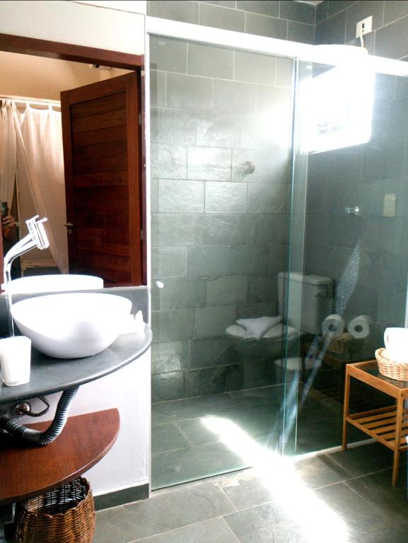 a bathroom with a glass shower and a sink at Flor da Mata in Pipa