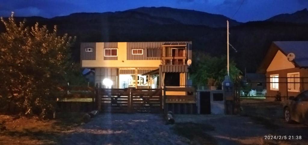 una casa de noche con una montaña en el fondo en BALCON CORDILLERANO en El Bolsón