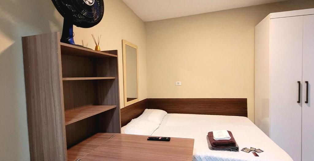 a small room with a bed and a book shelf at 40 LOFT DUPLO · LOFT perto do São Paulo Expo e metrô Jabaquara in Sao Paulo