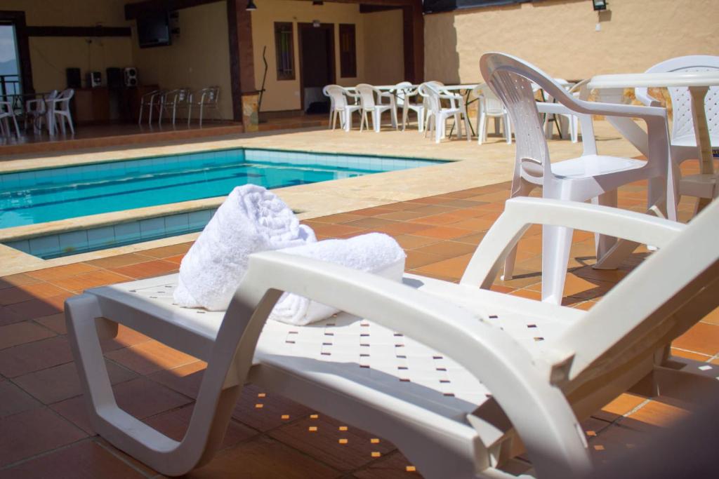 einen weißen Schaukelstuhl neben einem Pool in der Unterkunft Hostal Inn II Rionegro in Rionegro