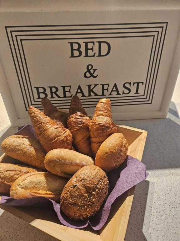 einen Haufen Brot in einer Holzkiste mit einem Schild in der Unterkunft Bed & Breakfast Serendipity in Valkenburg