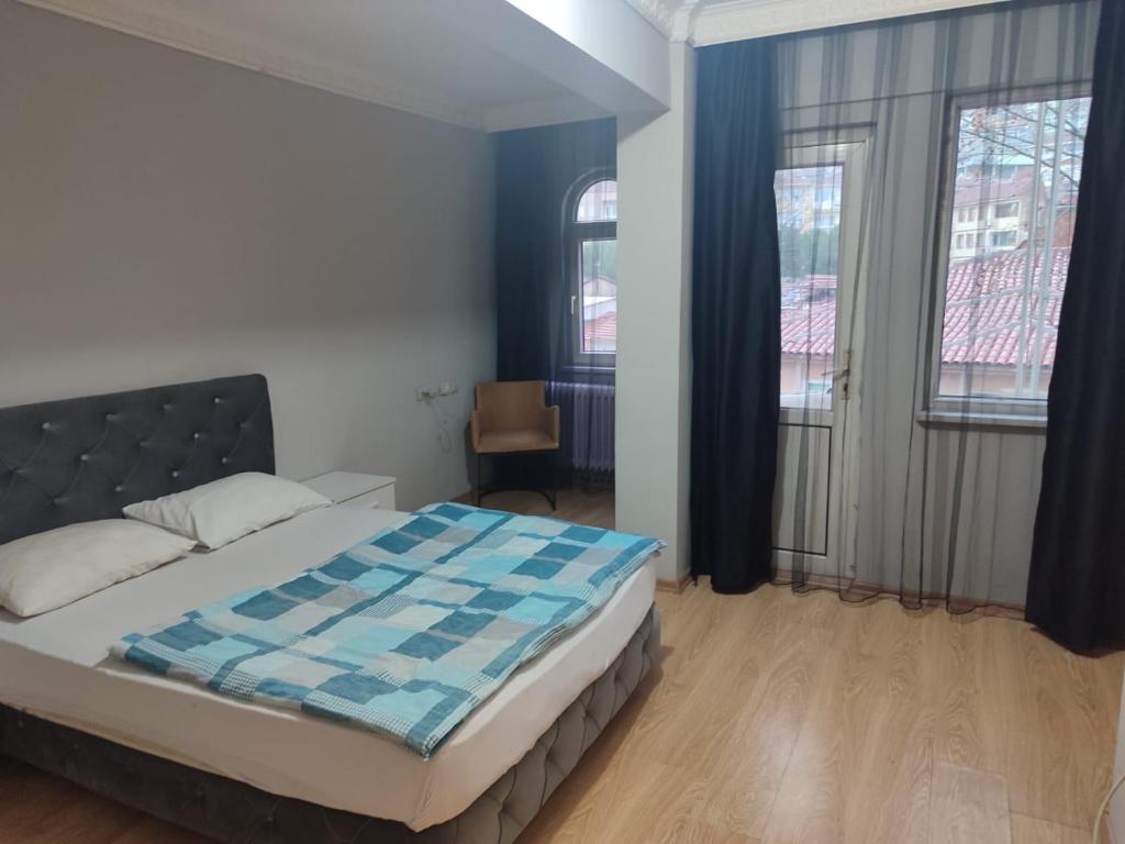 Un dormitorio con una cama con un edredón azul y blanco. en 1643 suit apart, en Çekirge