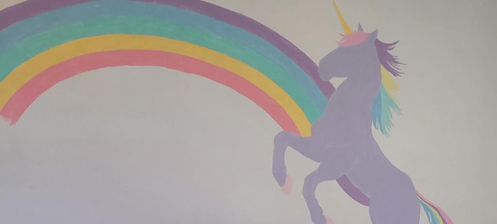 un unicorno con un arcobaleno su un muro di The Unicorn House - 9 min Park entrance - Pool, Outdoor Dining a Joshua Tree