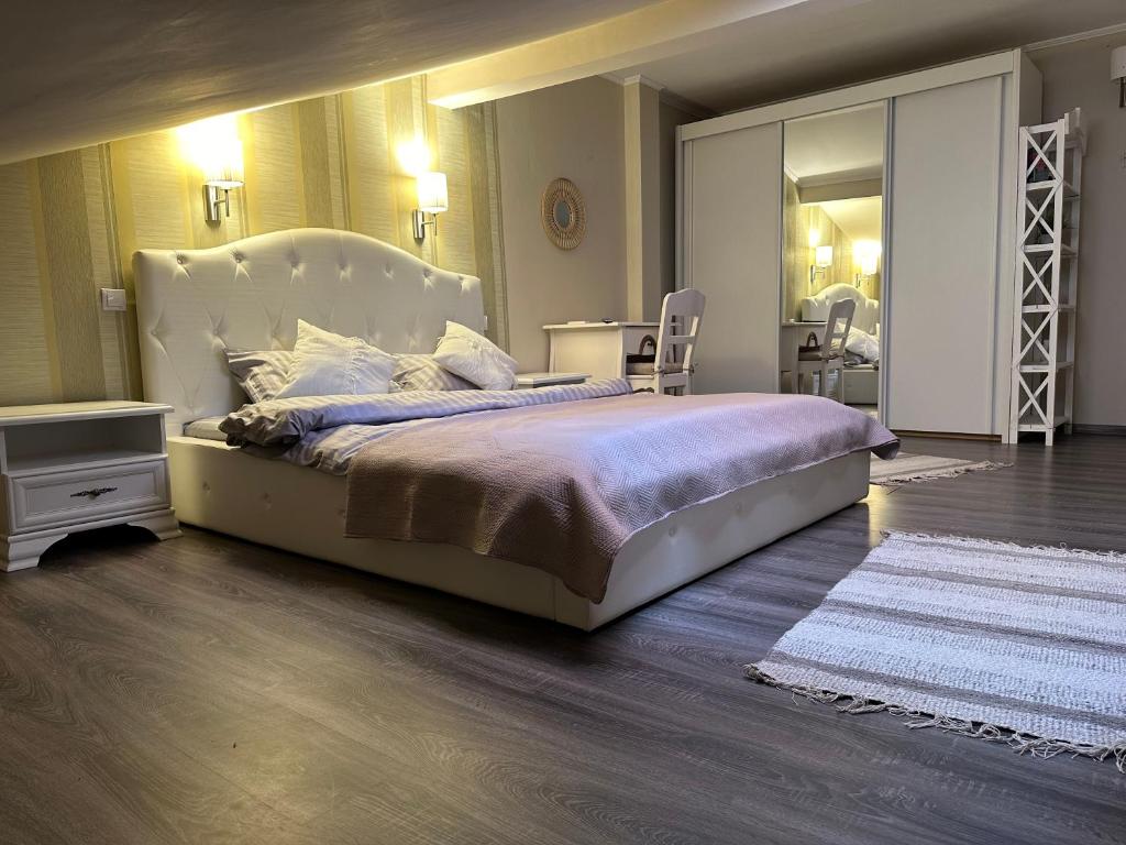 een slaapkamer met een groot bed en een spiegel bij Sunset apartment in Sângeorgiu de Mureş