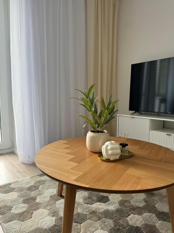 - un salon avec une table en bois et une plante dans l'établissement Apartment ZOi, à Šamorín
