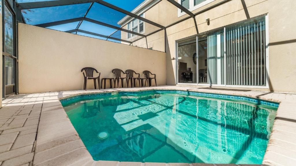 una piscina con sillas en una casa en The Pool Shack en Orlando