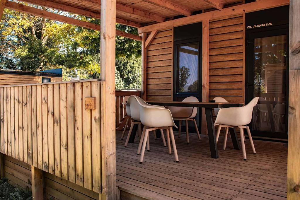 eine Holzterrasse mit einem Tisch und Stühlen darauf in der Unterkunft Nord mobile house in Velenje