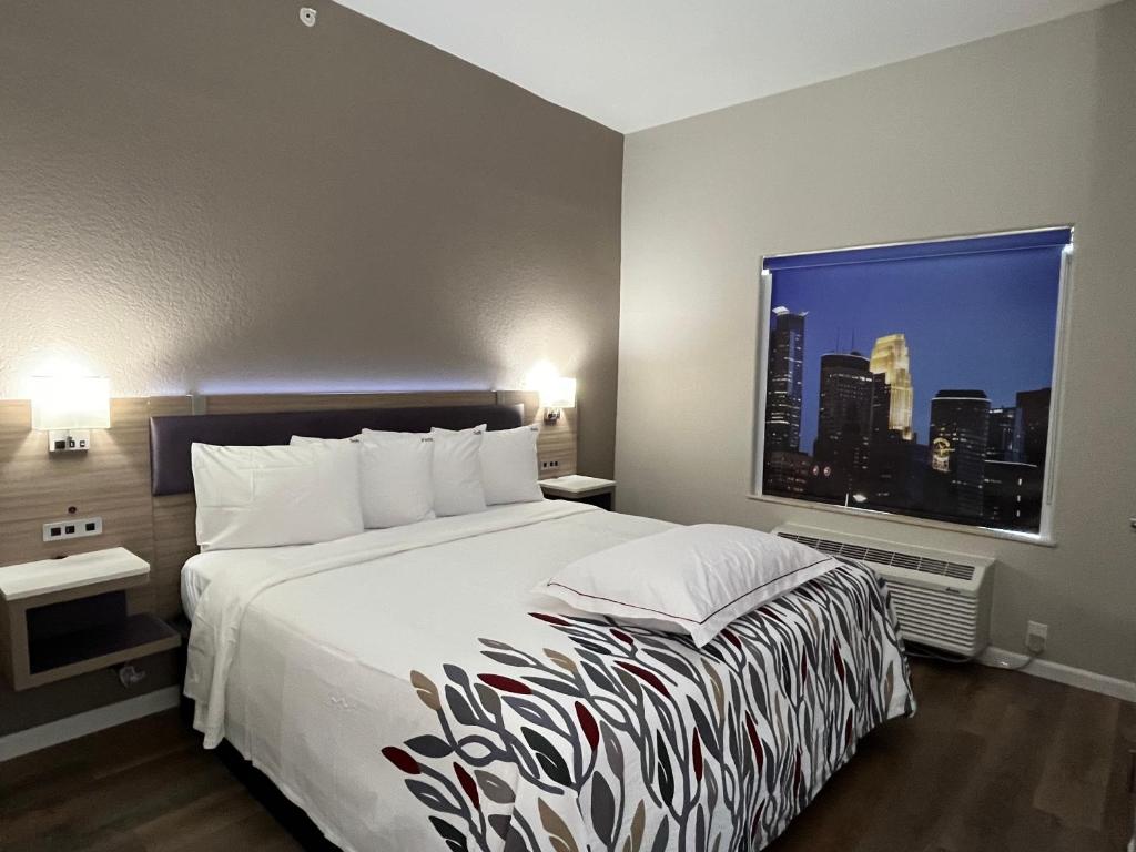 a hotel room with a bed and a large window at Red Roof PLUS San Antonio Northeast in San Antonio