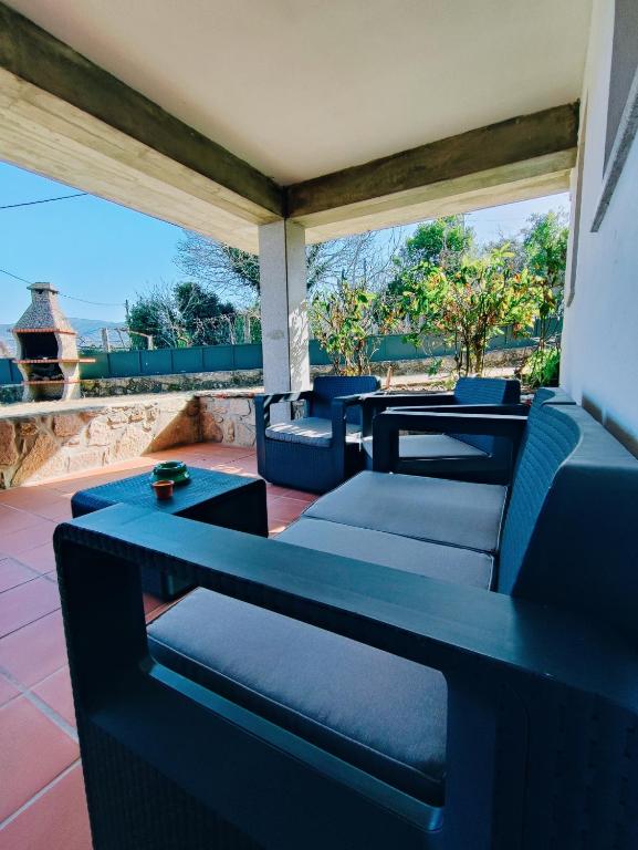 a patio with blue chairs and tables and a view of the ocean at Varanda do Outeiro in Melgaço