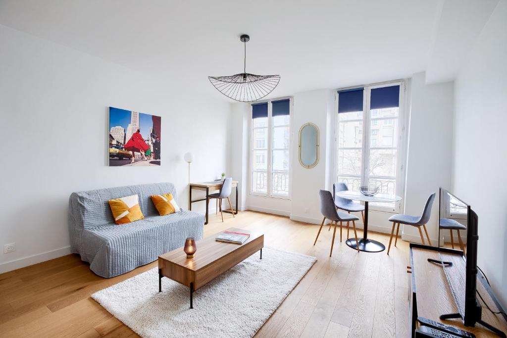 un salon avec un canapé et une table dans l'établissement Élégance Parisienne au cœur du Marais, à Paris