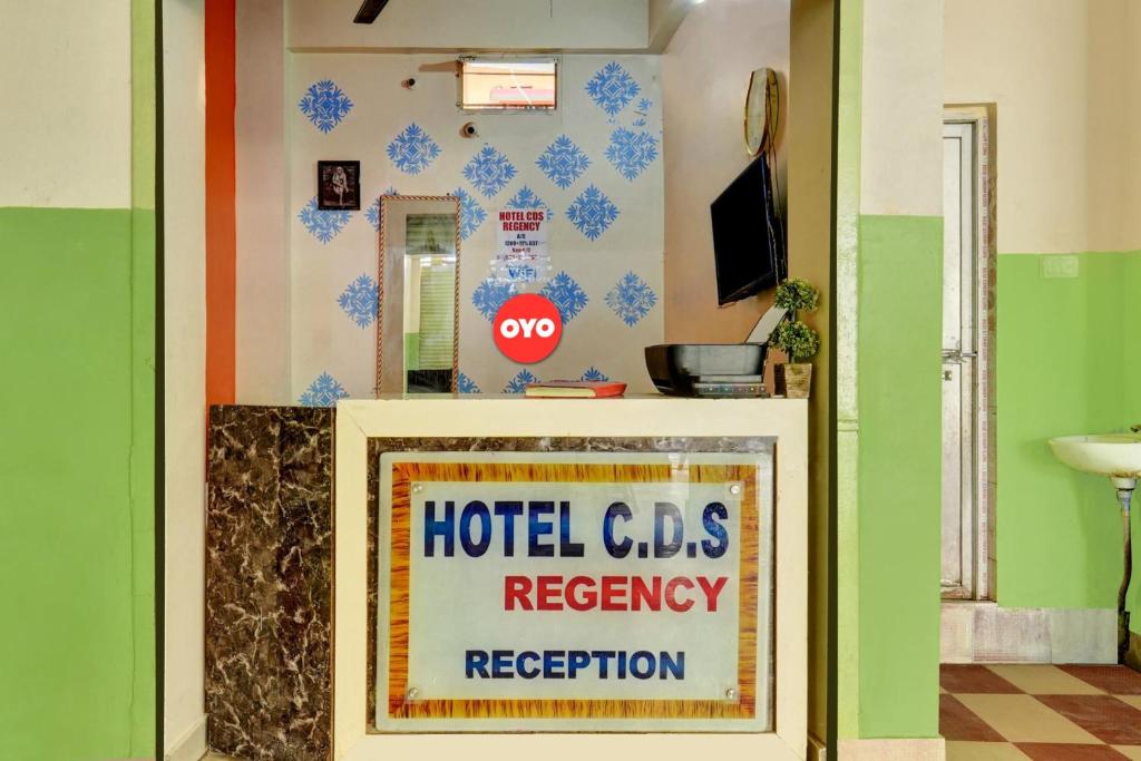 OYO Flagship Hotel CDS Regency في باتنا: علامة في غرفة مع cds استرداد مكتب الاستقبال