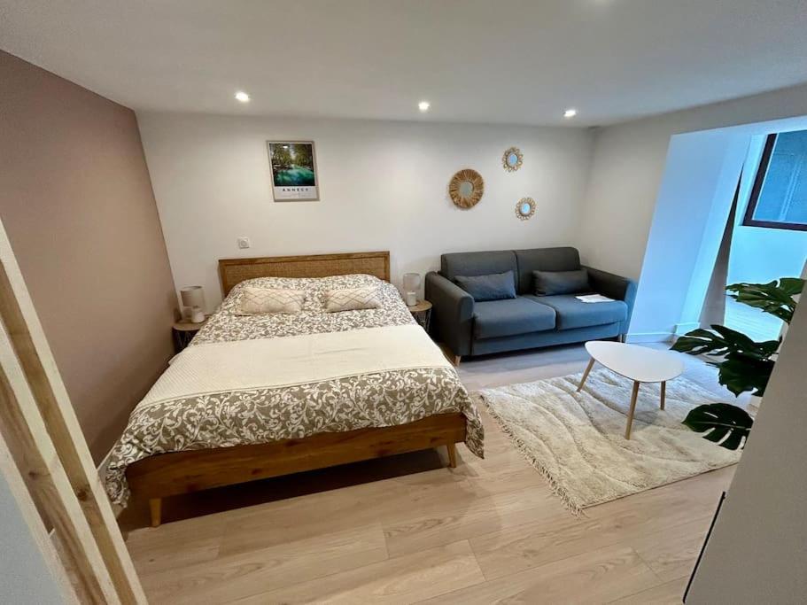 een slaapkamer met een bed en een blauwe bank bij Destination Royale in Annecy