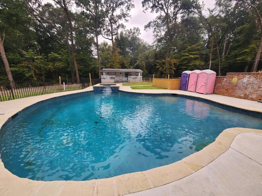 a large swimming pool with blue water in a yard at Turn of the Century Estate, Sauna Secluded in Memphis