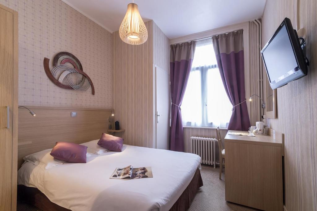 een hotelkamer met een bed en een flatscreen-tv bij Hotel Du Moulin d'Or in Lille