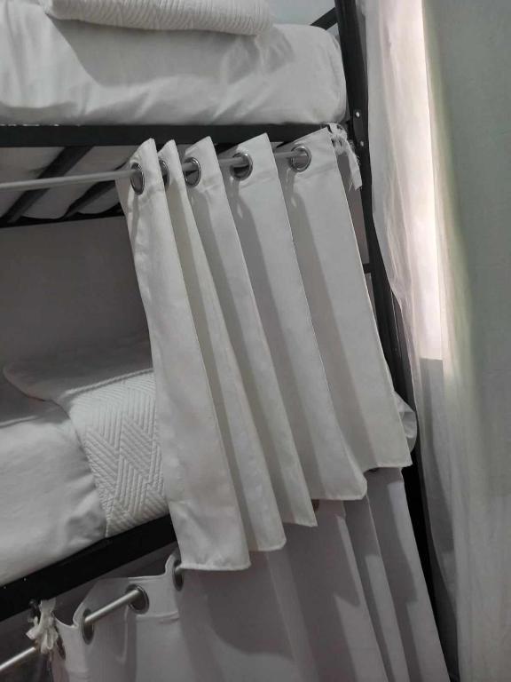利馬的住宿－HABITACIÓN COMPARTIDA MIXTA EN MIRAFLORES DE FAMILIA CON PRINCIPIOS Y VALOREs，双层床上的一双白色窗帘