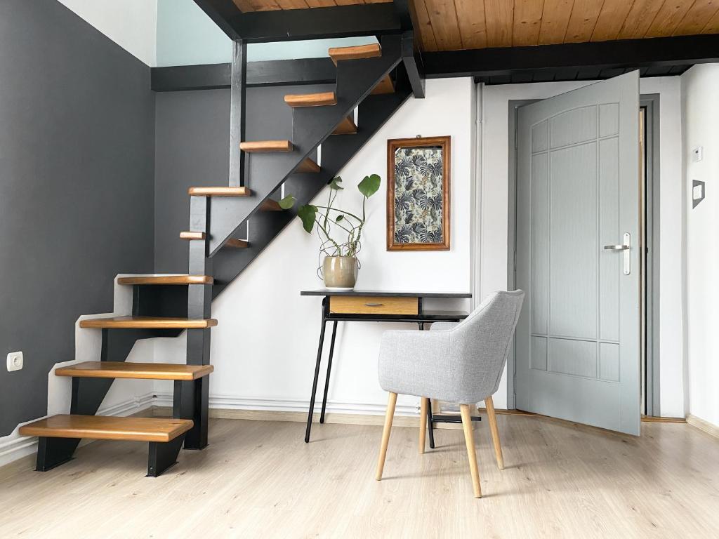 a staircase in a room with a desk and a chair at GREEN APARTMENTS #Nowy Square, Kazimierz district in Krakow