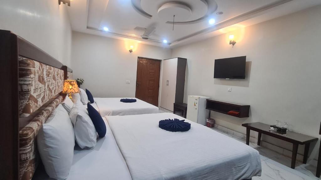 a hotel room with two beds and a tv at Hotel Executive Lodges in Bahawalpur