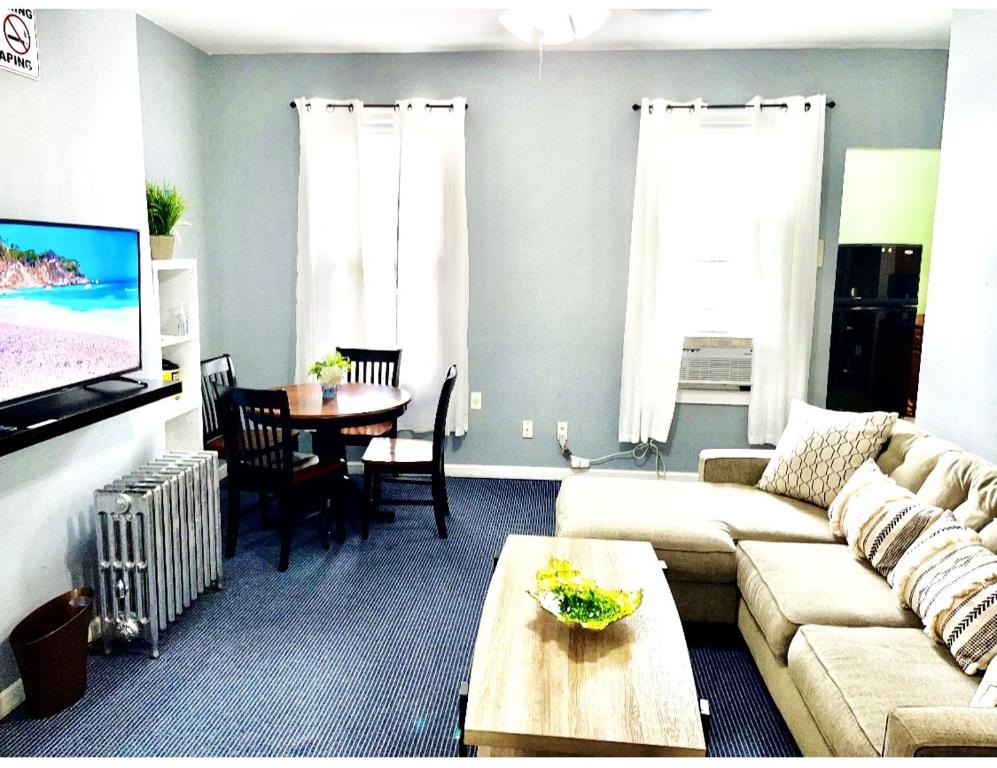 een woonkamer met een bank en een tafel bij 3 bedrooms 1 bath APT, 10 min to Manhattan! in Long Island City