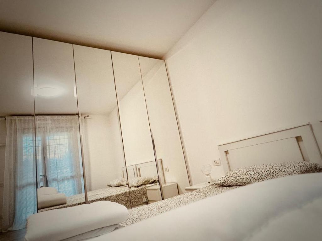 a white bedroom with a mirror and a bed at Maison Du Pic - Rho Fiera in Pero