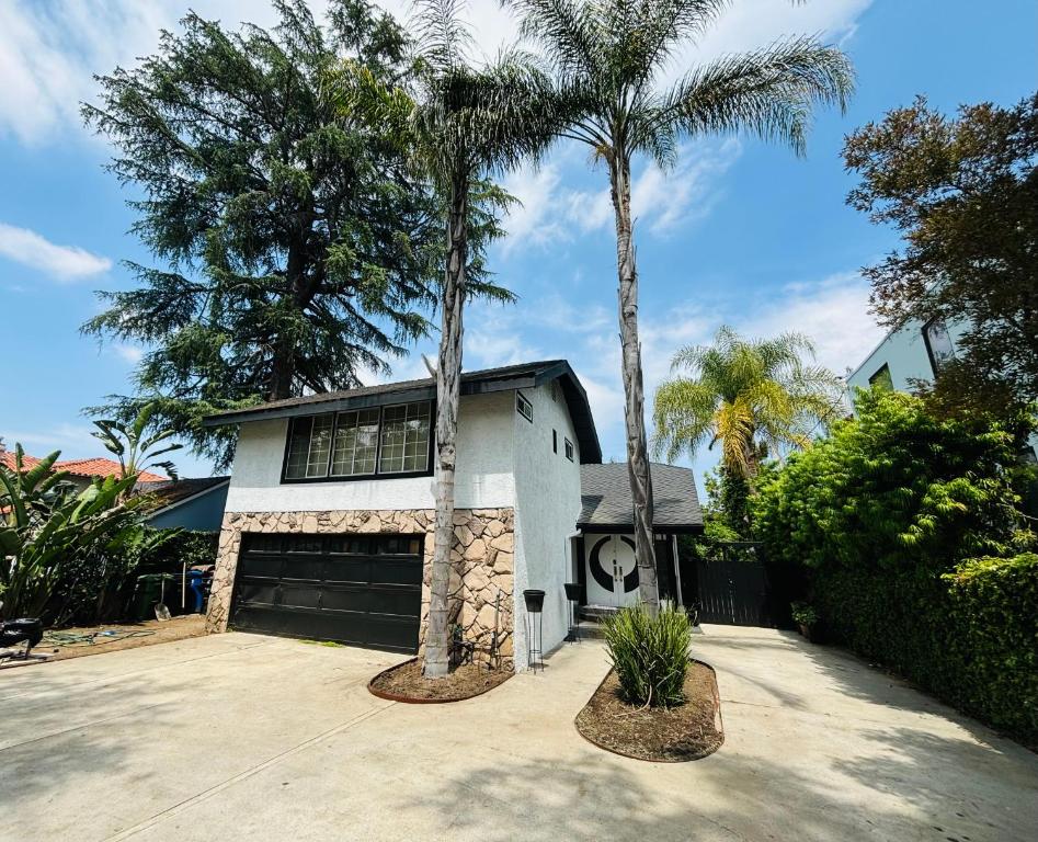 a house with two palm trees in front of it at Charming Duplex Home in Sherman Oaks in Los Angeles
