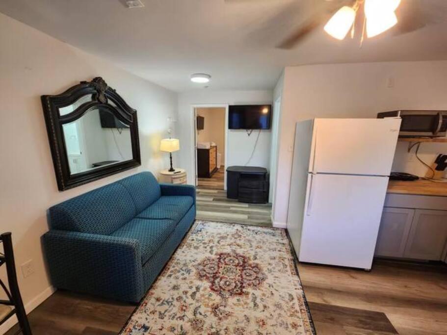 a living room with a blue couch and a refrigerator at Chic Rancher 7BR Compound Near Graceland & Airport in Memphis