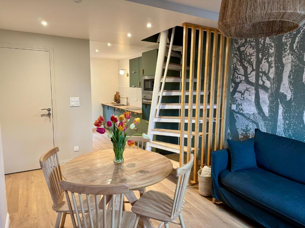 un soggiorno con tavolo e divano blu di L'Adresse - Rempart Sud - Eguisheim avec garage privé a Eguisheim