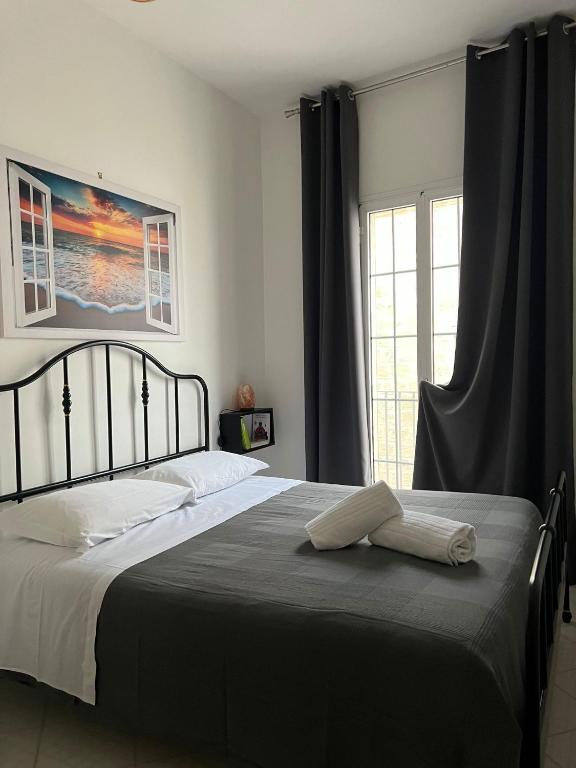 sypialnia z łóżkiem i oknem z zasłonami w obiekcie Suite San Benedetto, Terrazza vista mare w mieście Polignano a Mare