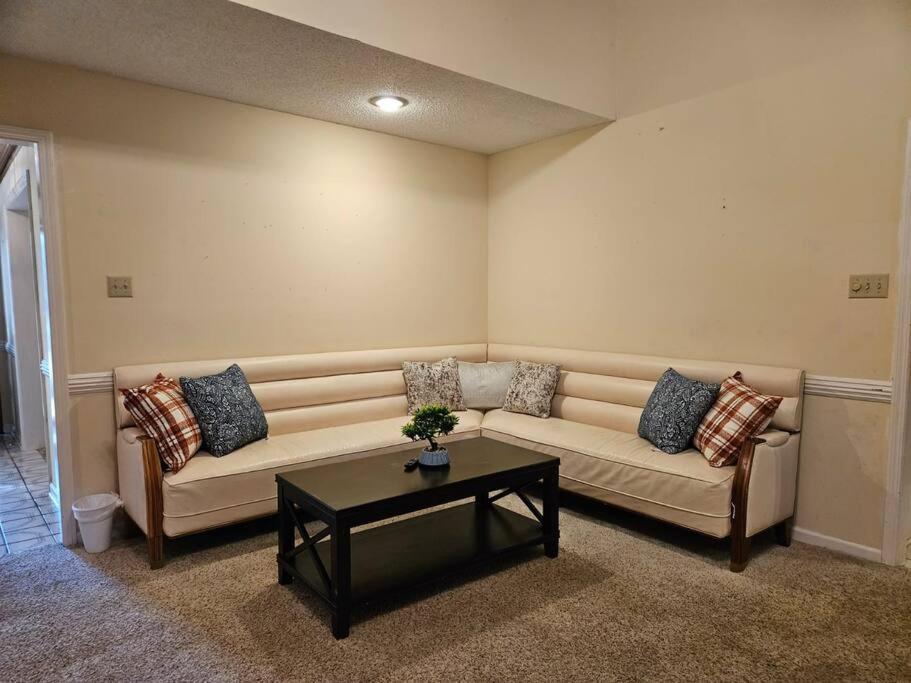 uma sala de estar com um sofá e uma mesa de centro em Peaceful & Elegant Sleeps 16 with Pool Near Mall em Memphis