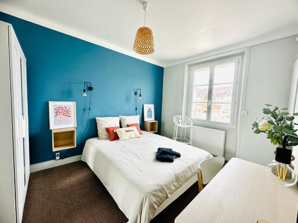 - une chambre avec des murs bleus et un grand lit dans l'établissement Le Cabieu, à Ouistreham