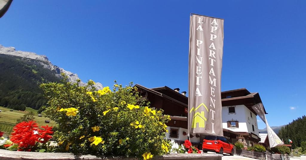 un hôtel dans les montagnes avec des fleurs devant lui dans l'établissement La Pineta Apartment, à Padola