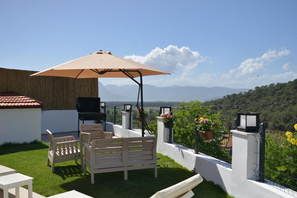 a patio with two chairs and an umbrella at HYVillaS HÜMA in Muğla