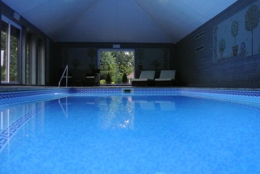 een groot blauw zwembad in een huis bij Frith Farm House Cottages in Newnham