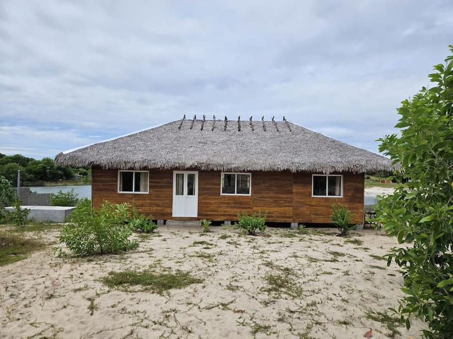 a small house with a straw roof on a beach at Villa Tropicale Fy in Mahajanga
