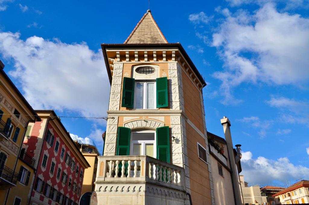 a tall tower with a green window and a steeple at La Torretta Boutique Accommodation in Rapallo