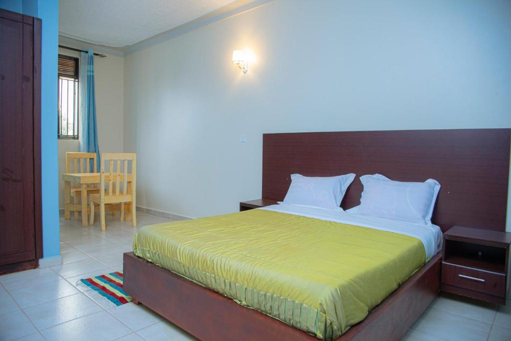 a bedroom with a large bed with a wooden headboard at the transit haven in Kampala