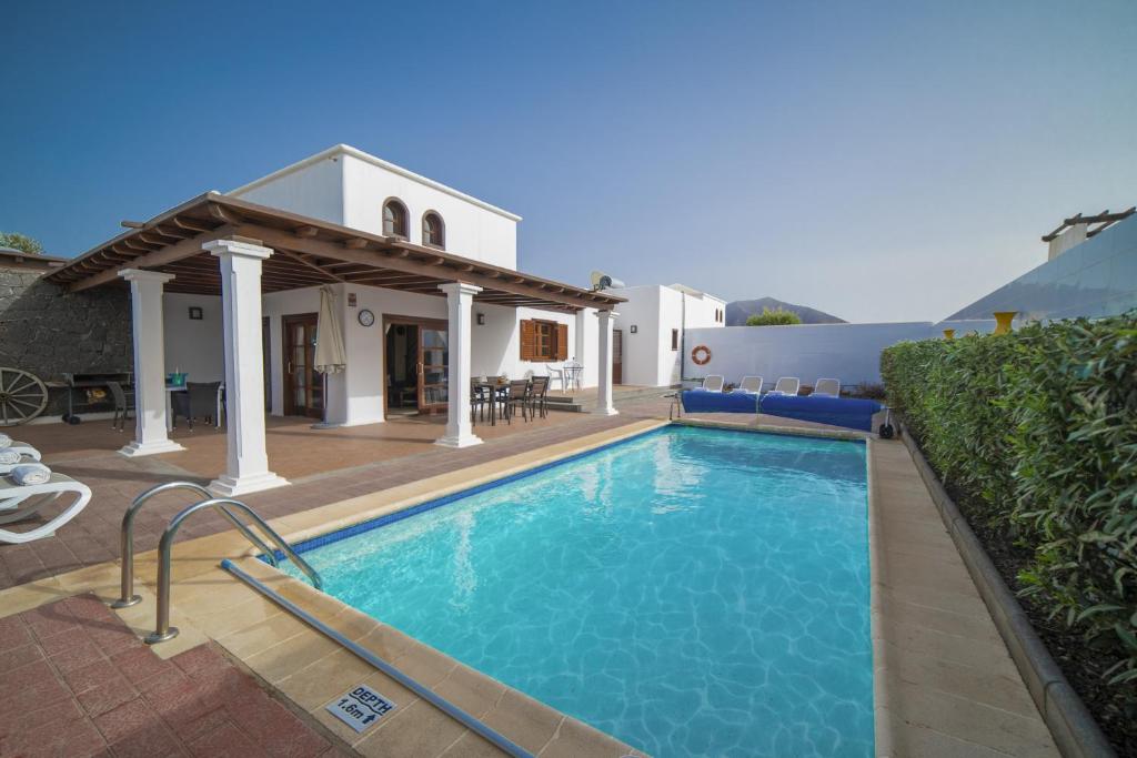 uma piscina em frente a uma casa em Sophisticated Lanzarote Villa | Villa Mervella | 4 Bedrooms | Spacious Terrace Area & Private Pool | Playa Blanca em Playa Blanca