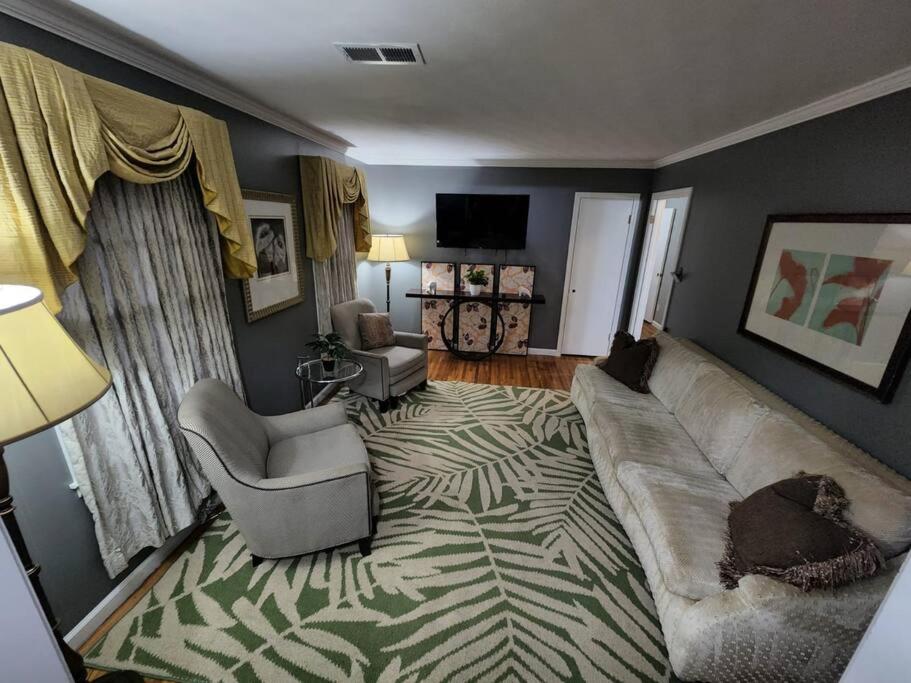 een woonkamer met een bank en een stoel bij Sits on an acre near Grace land with 3 full baths in Memphis