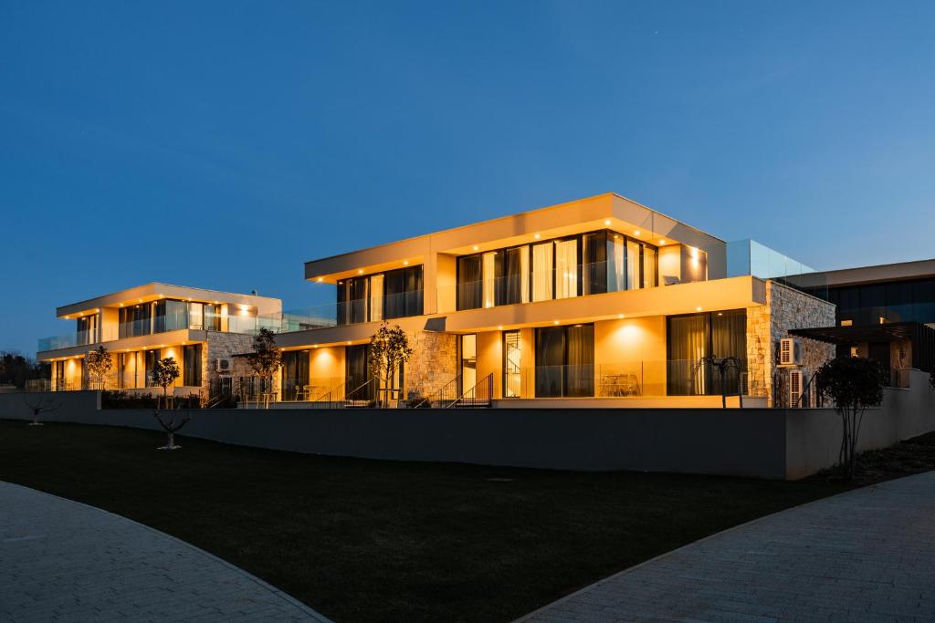 ein großes Gebäude in der Nacht mit eingeschaltetem Licht in der Unterkunft Villa within Resort, Umag, Istra in Savudrija