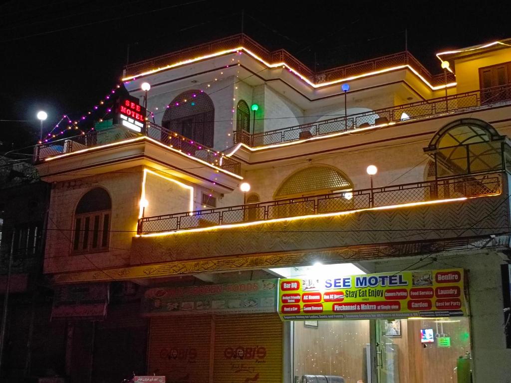 un edificio con un balcón encima por la noche en SEE MOTEL, en Muzaffarabad