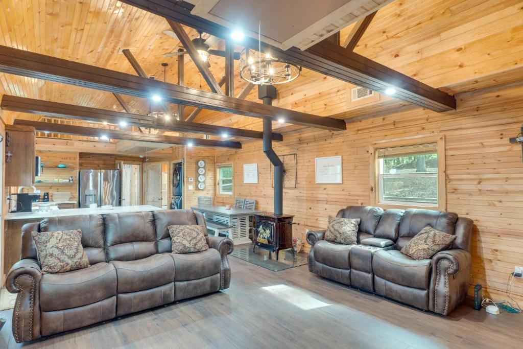a living room with two leather couches and a fireplace at Cozy Hemphill Cabin with Lake Views and Deck! in Hemphill