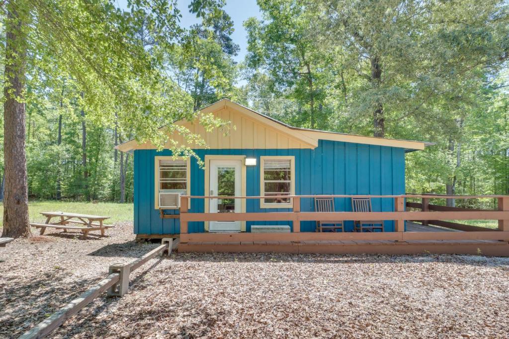 a blue tiny house in the woods with a picnic table at Quiet Hemphill Cabin Retreat Near Toledo Bend Lake in Hemphill