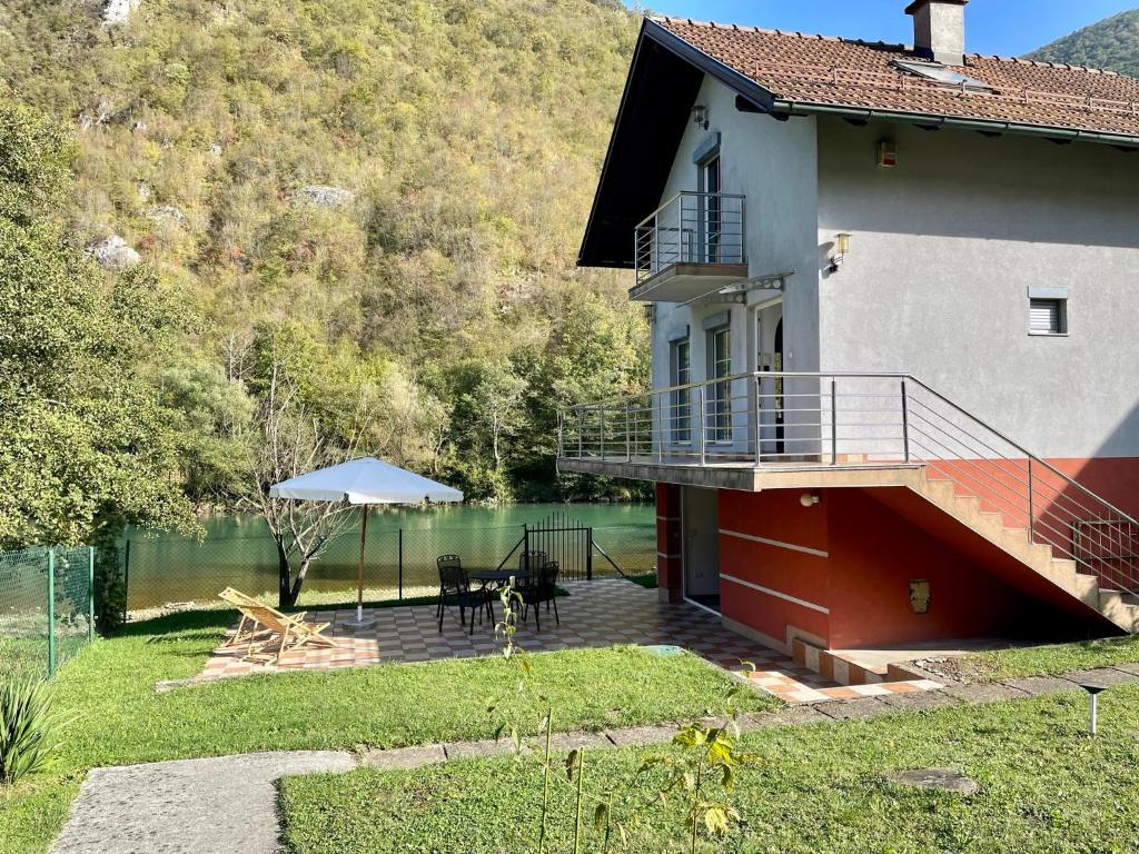 a house with a patio with a table and an umbrella at 069 Riverside Vikendica - Banja Luka in Rekavice