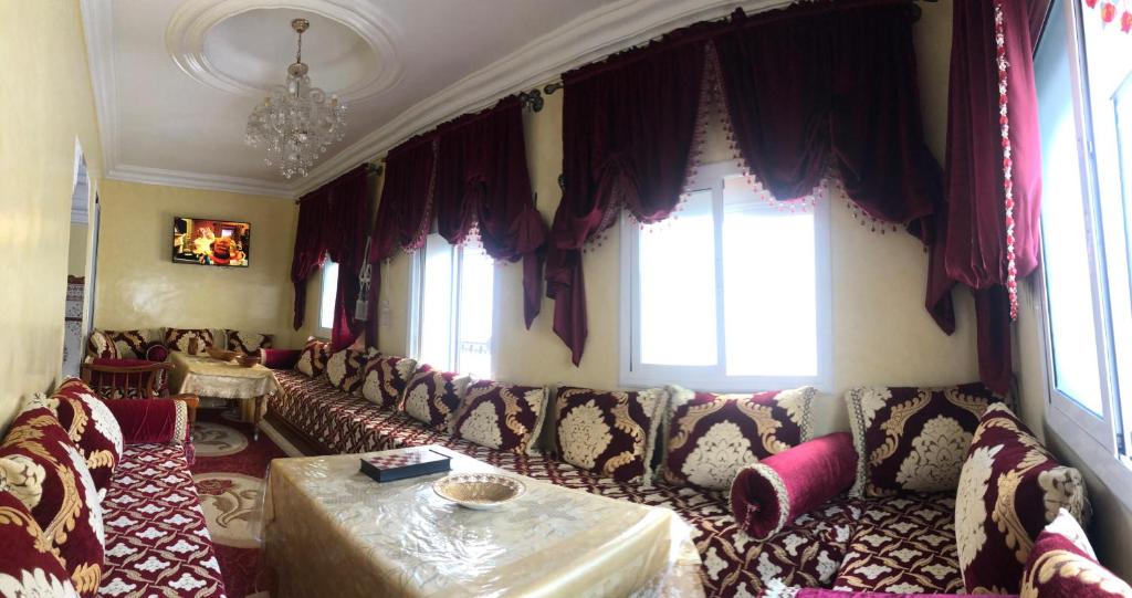 ein Wohnzimmer mit einem Sofa und einigen Fenstern in der Unterkunft old city apartment + free couscous on Friday in Tangier